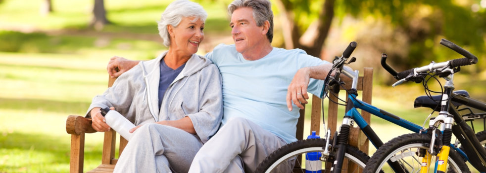 senior couple sitting on a bench outdoors
